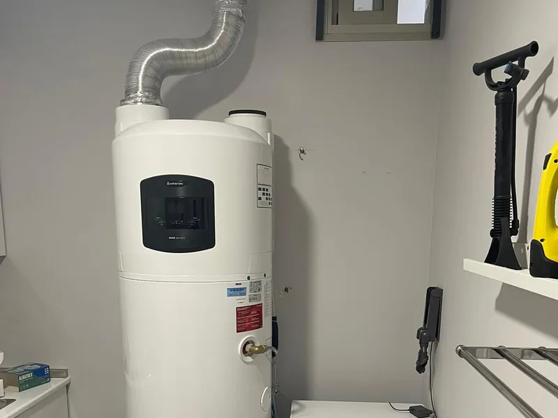 Bomba de calor Ariston Nuos Plus instalada en un lavadero, con el conducto de aire hacia el exterior