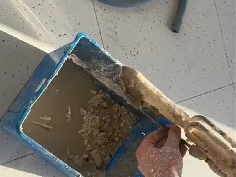 Resistencia de un depósito de agua caliente cubierta de cal, retirada durante una reparación